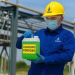Operador usando protección personal al manejar cloruro ferroso líquido.